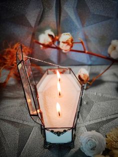 a white candle is lit in a glass container