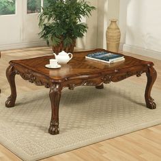 a wooden coffee table sitting on top of a rug next to a potted plant