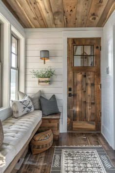 a living room with wood floors and a wooden door on the side of the house