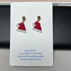 a pair of red and white santa hat earrings