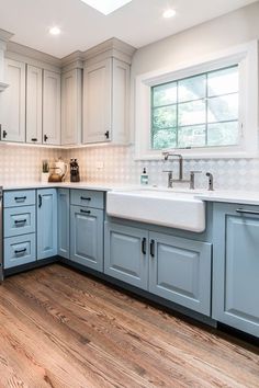 a kitchen with blue cabinets and wooden floors