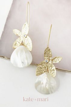 These sweet and delicate earrings feature a matte gold plated butterfly hook and a mother of pearl tear drop. Measures 2.5 inches long and 1 inch wide. Perfect for bridal earrings, rehearsal night earrings or bridesmaids earrings. Elegant bridal jewelry that can be the perfect piece of wedding jewelry for the bride on her special day or the statement jewelry piece for any special occasion. Shop these earrings and other elegant wedding jewelry pieces to add to your special day's jewelry set. Gold Mother Of Pearl Party Earrings, Gold Mother Of Pearl Earrings For Party, Gold Mother Of Pearl Earrings For Wedding, Honeymoon Accessories, Summer Wedding Earrings, Summer Wedding Jewelry, Elegant Wedding Jewelry, Handmade Wedding Jewellery, Wedding Accessories For Bride