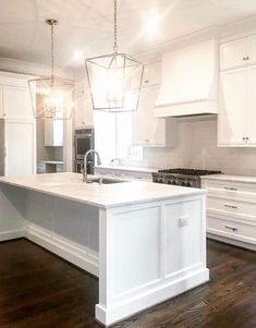 a large kitchen with white cabinets and an island in the middle of the flooring