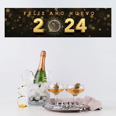 a bottle of champagne next to two glasses filled with ice and snowballs on a table