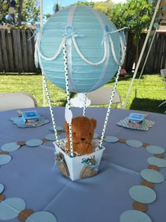 a teddy bear in a hot air balloon on a blue table cloth with polka dots