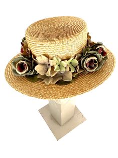 Romantic and elegant vintage style boater straw hat adorned with a composition of quality fabric flowers in shades of green and purple, attached to a 50 millimeter grosgrain ribbon. Made with 8/9 millimeters natural straw braid. Measurements in centimeters are 34 x 32. Crown height 9. Brim length 7. These measurements may have some slight variation depending on the size of the hat. For its elaboration we only use very good quality and resistant straw braids. In our workshop in the Pyrenees we se Adjustable Bohemian Straw Hat For Garden Party, Bohemian Boater Hat For Garden Party With Curved Brim, Bohemian Boater Hat With Curved Brim For Garden Party, Spring Bohemian Boater Hat With Short Brim, Bohemian Boater Hat With Short Brim For Spring, Bohemian Spring Boater Hat With Short Brim, Handmade Adjustable Boater Hat For Spring, Bohemian Boater Hat For Garden Party With Short Brim, Bohemian Straw Hat With Short Brim For Garden Party