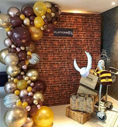 a balloon arch in the corner of a room with luggage and balloons hanging from it