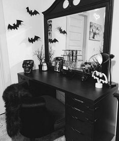 a black desk topped with a mirror and lots of bats on the wall behind it