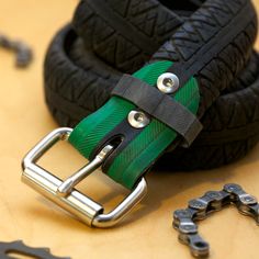 a green and black belt sitting on top of a table next to some wrenches