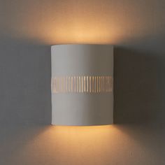 a white wall light mounted on the side of a wall next to a gray wall