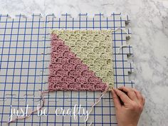 someone is crocheting a square with yarn