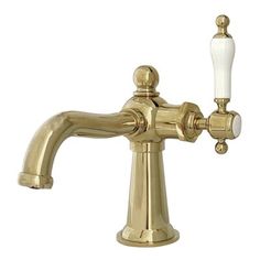 a gold faucet with two white knobs on the side and one light