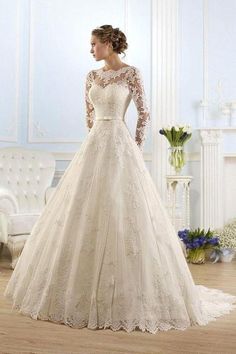 a woman in a wedding dress standing on a wooden floor