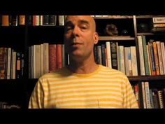 a man standing in front of a book shelf filled with books