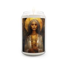 a candle with an image of the virgin mary holding a cross in her hands, on a white background