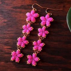 pink beaded earrings on a wooden table