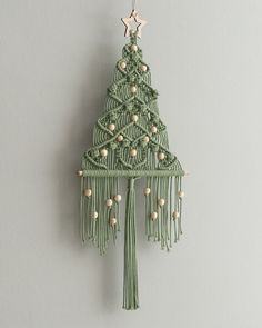 a green christmas tree ornament hanging on a wall