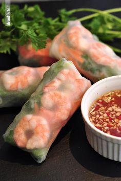 some food is sitting on a table with dipping sauce in the bowl and garnished with parsley