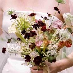 a bride holding a bouquet of flowers in her hands