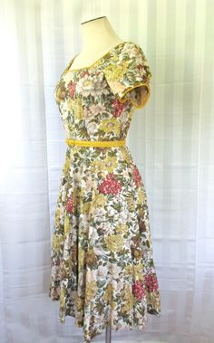 Pretty vintage dress from the 50s or possibly very early 60s. The fabric is a fine cotton or cotton sateen - with a very subtle sheen. Lovely detail of rhinestones scattered along the front of the skirt section. Trim of ochre yellow along the neckline in front and back and the edge of the sleeve, matching the color of the belt. Double bust darts. Colors also include light blue, dusty rose and light coral. Measurements taken with the dress lying flat: Bust is 34-1/2 inches. Waist is 25-1/2 inches Fitted Cotton Vintage Dress For Daywear, Retro Cotton Vintage Dress With Vintage Pattern, Cotton A-line Vintage Dress, Fitted Cotton Vintage Dress For Garden Party, 1950s Short Sleeve Vintage Dress For Garden Party, Fitted Vintage Cotton Dress With Floral Print, Retro Cotton Dress With Vintage Pattern, Cotton Vintage Dress With Vintage Print For Daywear, Cotton Vintage Print Dress For Daywear