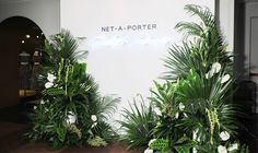 some plants are on display in front of a sign that says net - a - porter