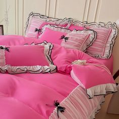 a bed with pink sheets and black bows