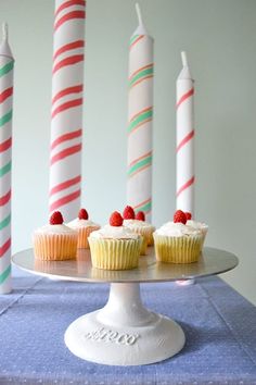 cupcakes on a cake plate with candles in the background