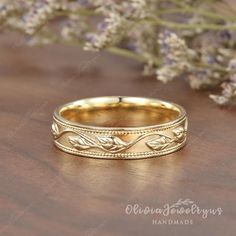 a gold wedding ring sitting on top of a wooden table