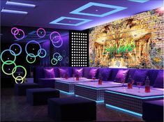 an empty room with purple couches and neon lights on the walls, along with black tables