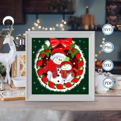 a christmas card with a snowman in a wreath and reindeers around it on a table