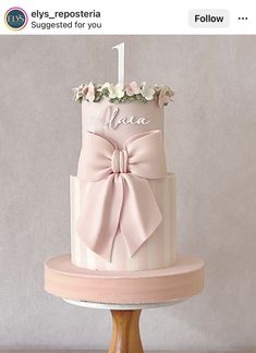 a pink and white cake with a bow on it's top that says i love you