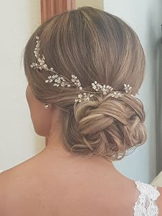 a woman wearing a bridal hair comb with flowers in it's back and side