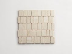 a piece of wood that has been made out of small blocks of white tile on the wall