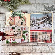 an open christmas card on top of a wooden table next to a wreath and other decorations