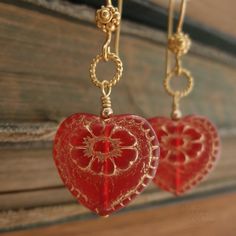 "Beautiful red glass hearts, etched in gold, hang from delicate, twisted wire loops and decorative earwires of vermeil. A lovely gift for yourself or somebody else on Valentine's Day. Length from bottom loop of earwire: 1\"(25mm) Diameter of heart: 3/4\"(20mm) All Debra Dane jewelry arrives in a pretty box suitable for gifting. These earrings are also available with non-pierced gold plated clips. They will have a gold ball instead of the ornate piece that is on the pierced earwires." Heart-shaped Jewelry With Ear Wire For Gifts, Red Dangle Heart Earrings As A Gift, Red Dangle Heart Earrings For Gift, Gold Heart Earrings For Gift, Red Heart Beads Earrings For Gift, Red Ear Wire Jewelry For Valentine's Day, Heart Pendant Earrings With Beads For Gift, Heart Pendant Earrings With Heart Beads, Red Jewelry With Ear Wire For Valentine's Day