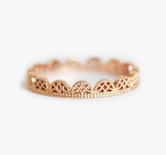 a gold ring with intricate designs on the inside and outside, set against a white background