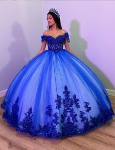 Step into your dream Quinceanera with the Fiora Ball Gown. This exquisite gown features a classic ball gown silhouette, beautifully crafted from layers of luxurious tulle fabric that add volume and movement to your every step. It is available in vibrant colors like royal blue, red, pink, purple, and green. The lace-up back ensures a perfect fit, accentuating your figure while adding a touch of classic charm. The intricate applique details and delicate beading sparkle with every turn, making you Aqua Blue Sweet 16 Dress, Azul Rey Quinceañera Dresses, Sweet 15 Dresses Quinceanera Blue, Xv Dresses Royal Blue, Royal Blue Sweet 16 Dresses Ball Gowns, Royal Blue 15 Dress, 15 Dresses Quinceanera Royal Blue, Dark Royal Blue Quinceanera Dresses, Xv Dresses Blue