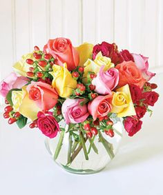 a vase filled with lots of different colored roses