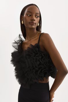 A must-have for the holiday season, the FELETA ruffle tulle top epitomizes the perfect blend of modern luxury and playful charm. A v-neckline and delicate thin straps adds a touch of allure and sophistication to its chic cropped length. The top is adorned with ruffled tulle throughout the bodice, creating an ethereal and romantic look perfect for a range of occasions, from casual outings to formal events. Style it with a leather trouser for a captivating look. Ruffle Tulle Top, Leather Halter Top, Tulle Top, Leather Bustier, Black Mesh Top, Bow Detail Dress, Romantic Look, Satin Top, Cotton Tank Top