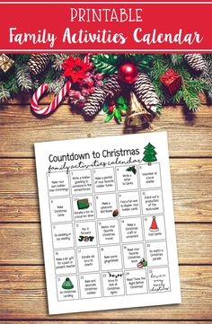 the printable family activities calendar for christmas is displayed on a wooden table with candy canes and pine cones