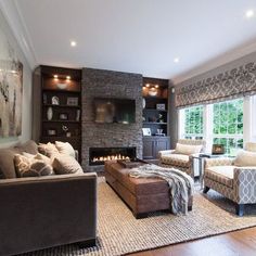 a living room filled with furniture and a fire place in the middle of it's wall