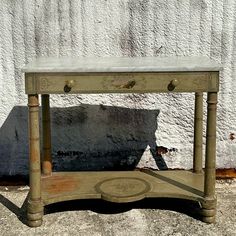 an old wooden table with marble top