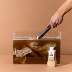 a person is using a brush to clean an animal's skin in a clear container