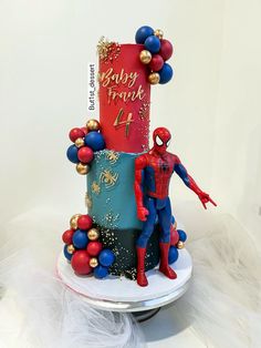 a spiderman themed birthday cake with balloons