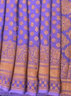 SILK MARK CERTIFIED !!!Stunning Lavender Color Pure Khaddi Georgette Silk Saree with Copper Zari and Wide Border. Floral Pattern Jaal on the border and Big Floral Butta on the Pallu giving it a grand look. Quite a Unique Color and Pattern Saree making it - A MUST HAVE in your Wardrobe !! Saree Fabric : Pure Khaddi Georgette Silk Color : Lavender Blouse piece : Comes with un-stitched Blouse piece.Fall & Edging(Yes/No) : YesSilk Mark Certificate given with the Saree(Yes/No) : Yes Disclaimer :-- Co Lavender Dupatta With Pallu For Wedding, Festive Lavender Fitted Dupatta, Fitted Lavender Saree With Zari Work, Lavender Saree With Dupatta In Traditional Drape, Lavender Saree With Dupatta Traditional Drape, Bollywood Style Lavender Saree, Silk Lavender Dupatta For Wedding, Fitted Lavender Traditional Wear With Zari Work, Elegant Lavender Traditional Wear With Pallu