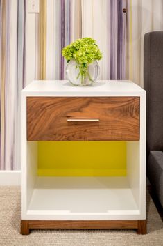 a white and yellow nightstand with flowers on top