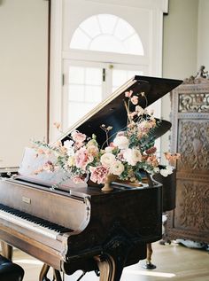 a grand piano with flowers on it in a room