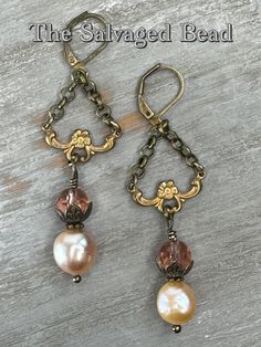 "Inspired by the turn of the 20th century, this gorgeous dangle pair of blush glass and champagne baroque freshwater pearl earrings.  Set in vintage Victorian brass stampings, roll chain, and Czech glass beads. Beautifully elegant and rich in history.  These earrings hang approximately 2 inches. Perfect for any season, to wear into the office, a dressy occasion, or a night on the town!  Own a piece of history, and pass it down as a family heirloom, these earrings are sure to be an eye-catcher! This listing is for 1 pair of earrings. Lavaliere necklace sold separately find it here:  https://thesalvagedbead.etsy.com/listing/1662429924 Each piece is unique & crafted with true artistry. I very much enjoy both the \"picking process\" (the hunt) to research & find the right pieces to marry toget Elegant Antique Gold Jewelry With Lobster Clasp, Vintage Pearl Drop Jewelry Gift, Vintage Pearl Drop Jewelry For Gift, Vintage Wire Wrapped Dangle Jewelry, Vintage Brass Wire Wrapped Earrings, Vintage Wire Wrapped Brass Earrings, Vintage Nickel-free Pearl Earrings For Wedding, Vintage Metal Pearl Earrings For Gift, Vintage Teardrop Pearl Earrings