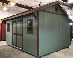 a small green building in a warehouse