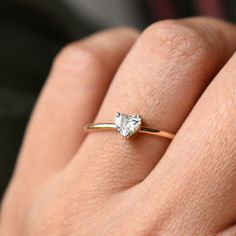 a person's hand with a ring on it and a diamond in the middle